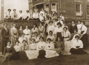 Sepia photo of forty women in Edwardian dress standing outside University House (current day Business School), the first permanent women's halls of residence.  