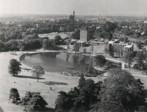 Black and white aerial photo of new halls of residence around the lake at the Vale, with the Birmingham skyline in the distance